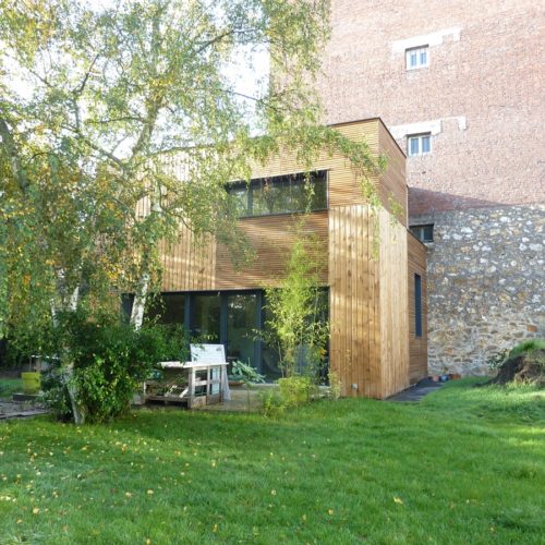 Photo couleur d'une maison en bois et son jardin construite par le cabinet TB'Home