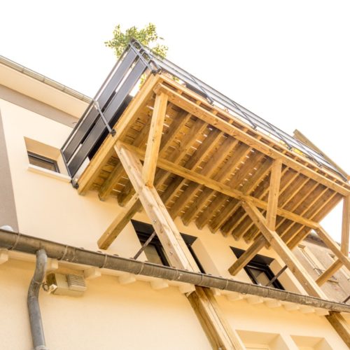 Photo vue du dessous de la terrasse en bois extérieur d'une maison rénovée